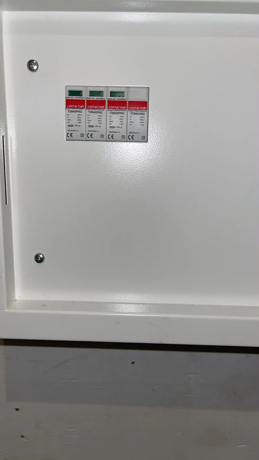 Close-up of surge protection modules in a white electrical distribution enclosure.