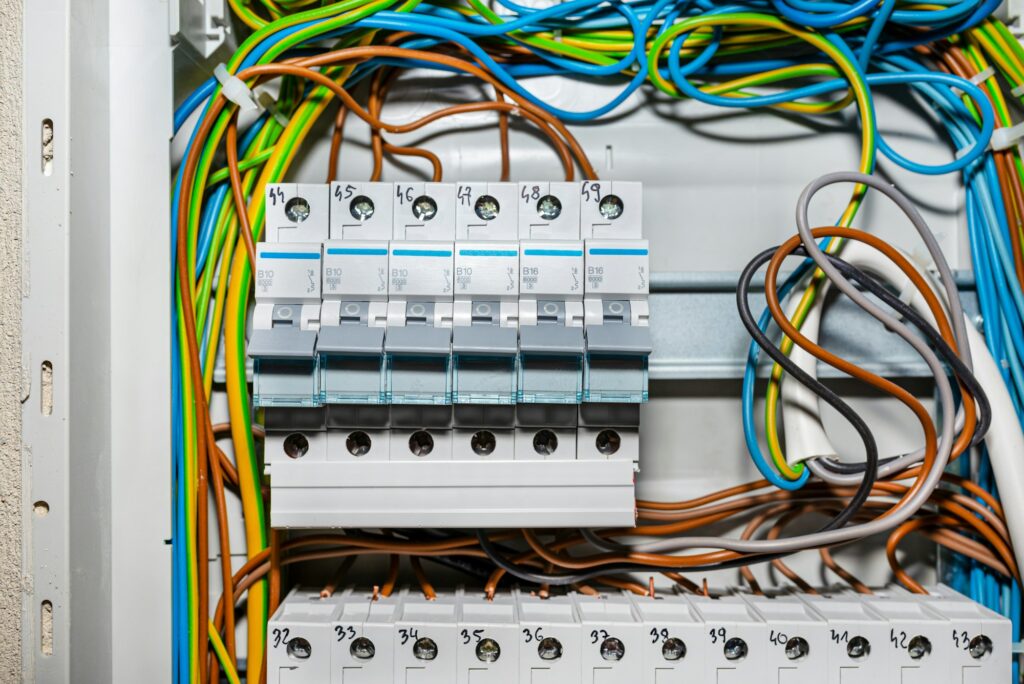 Single-phase fuses in the OFF position, placed in the home fuse box, visible electric wires.one phase | Commercial EICR